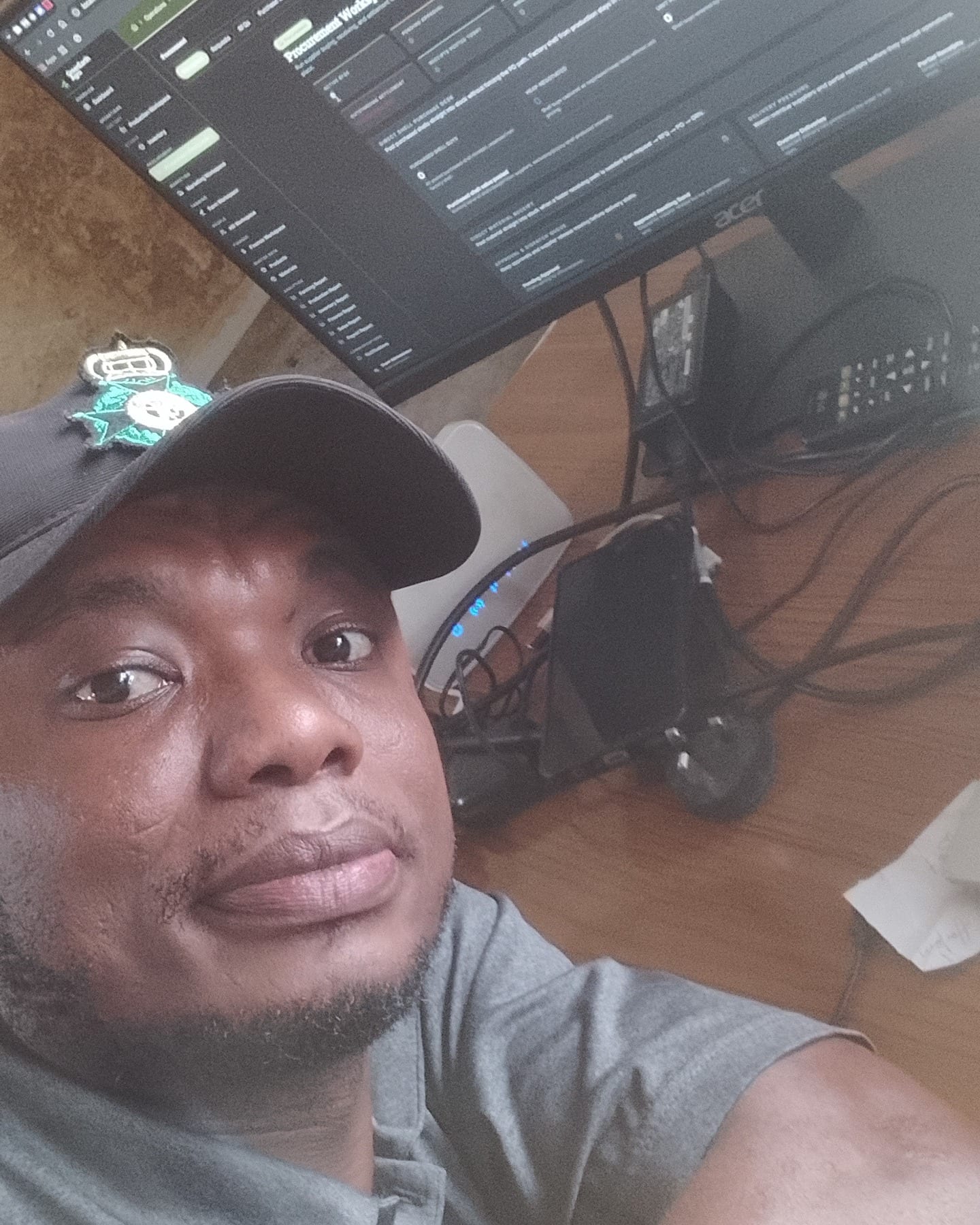 Timothy Essuman at a workstation on the factory floor at Ajumako, the ERP's procurement workspace open on the monitor behind him.